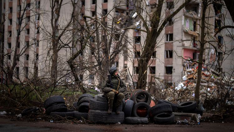 Tschernihiw im Norden der Ukraine: Ein Soldat der ukrainischen Armee sitzt vor einem zerstörten Wohnhaus.