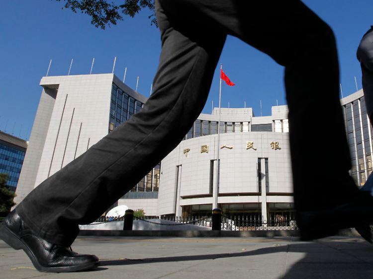 Ein Passant, der es eilig hat, vor dem Gebäude der chinesischen Notenbank in Peking.