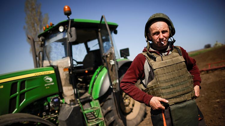 Juri, ein Bauer aus der Nähe von Saporischschja, geht mit Helm und schusssicherer Weste aufs Feld.