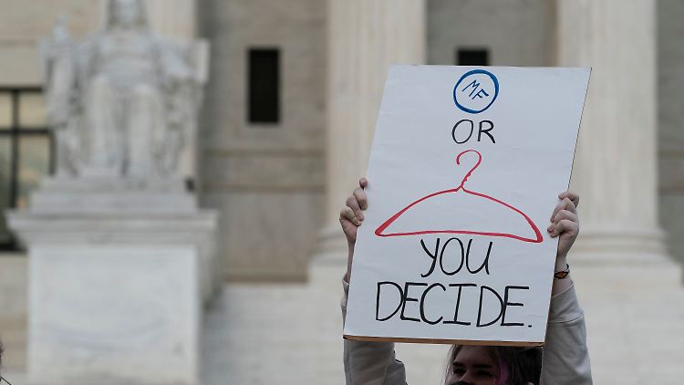 Eine Demonstrantin vor dem Supreme Court macht die Folgen des für Juni erwarteten Urteils deutlich: Abtreibungspille oder Kleiderbügel.