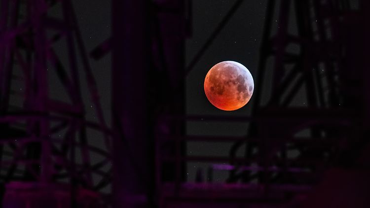 Ein sogenannter "Blutmond" scheint durch eine Industrieanlage in Duisburg (Bild von 2019).