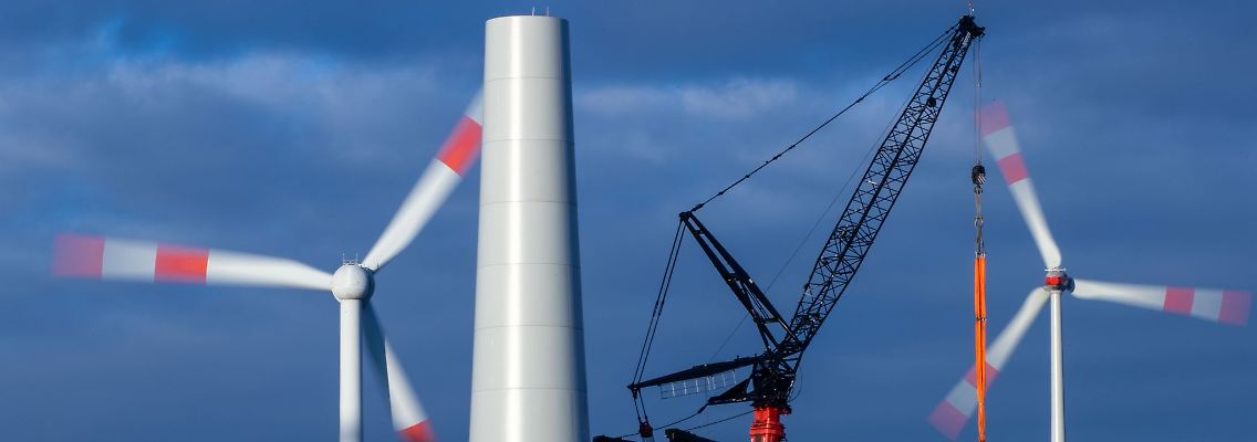 In einem bestehenden Windpark wird ein Turm für eine neue Anlage errichtet.