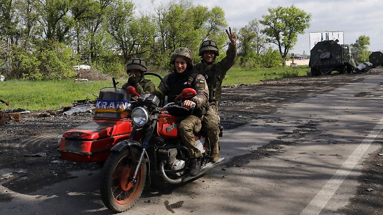 Ukrainische Soldaten fahren auf einer zurückeroberten Straße.