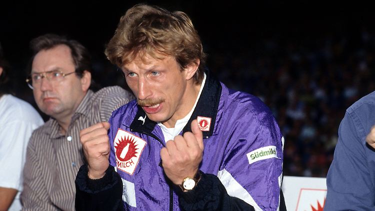 Christoph Daum in einem modischen Trainingsanzug.