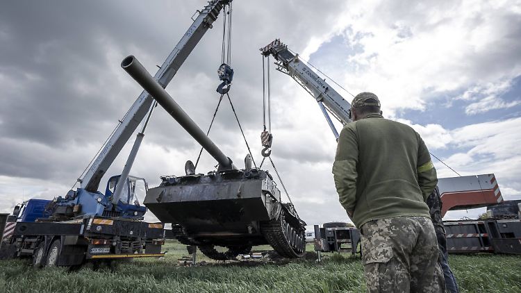 Ukrainer schleppen einen erbeuteten russischen Panzer in der Nähe von Charkiw ab.