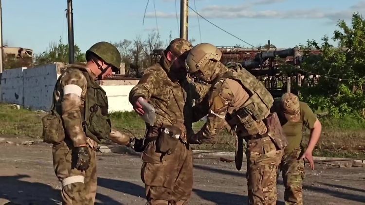 Asowstal-Kämpfer, die ihre Waffen niedergelegt haben, werden von russischen Soldaten kontrolliert.