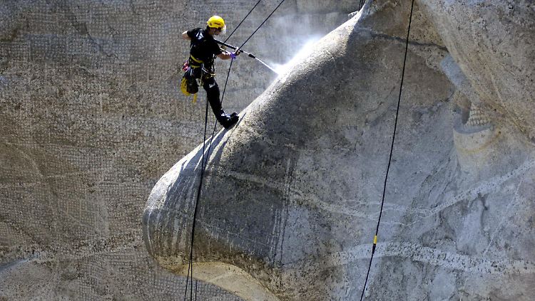 Spezialreinigung für Oberflächen in aller Welt: Am Mount Rushmore im US-Bundesstaat South Dakota säubert ein Kärcherianer am Seil hängend die Nase eines steinernen US-Präsidenten (Archivbild).