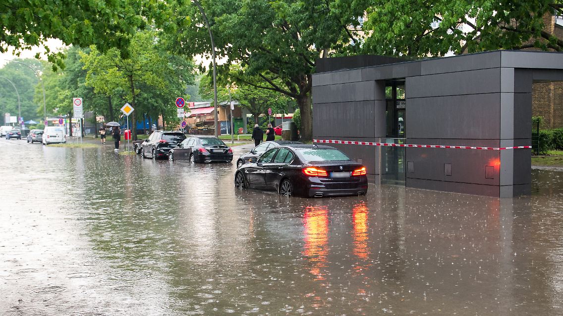 Nach starkem Regen in Hamburg stehen Autos im Wasser.