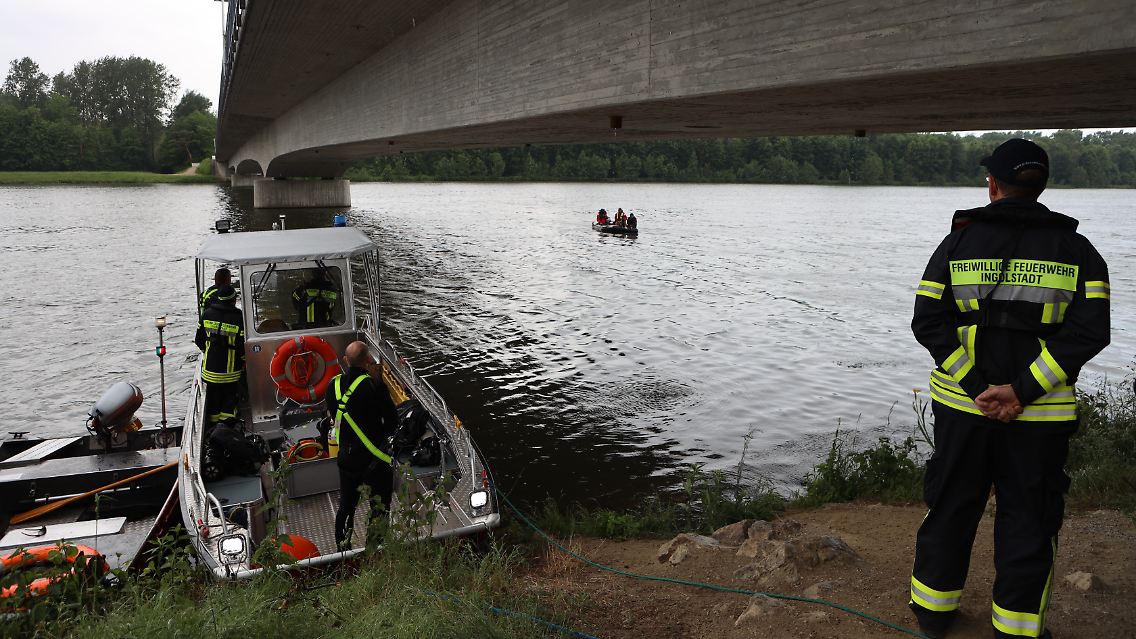 Rettungskräfte stehen am Ufer der Donau in der Nähe des Fundortes.