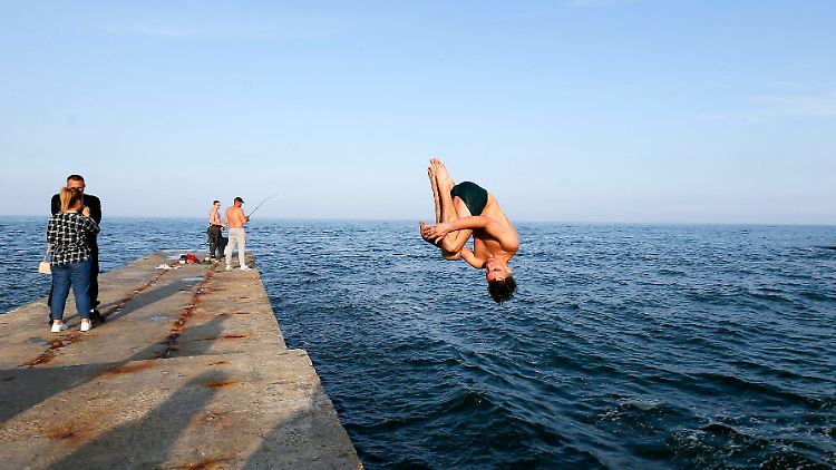 Die Strandsaison beginnt in Odessa normalerweise Ende Mai. Jetzt ist der Strand gesperrt - einige Jugendliche springen daher vom Pier.