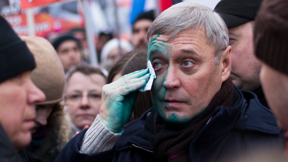 Michail Kassjanow wischt sich 2017 bei einem Gedenkmarsch für den ermordeten Oppositionspolitiker Boris Nemzow nach einem Angriff Farbe aus dem Gesicht.