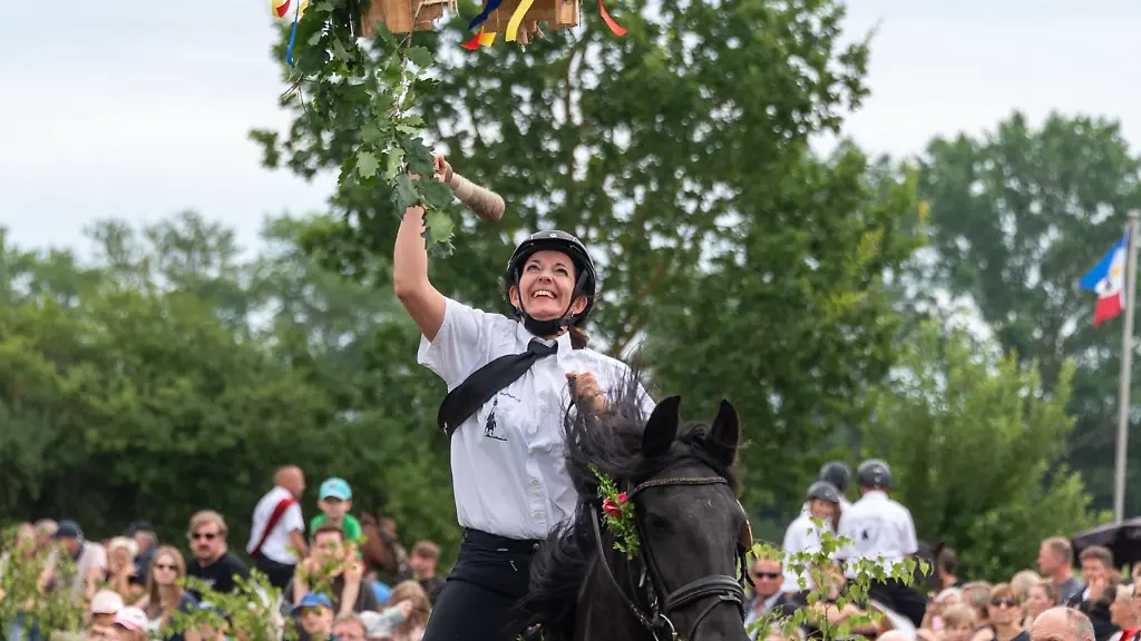 Eine-Reiterin-schlaegt-mit-einem-Knueppel-auf-eine-Heringstonne
