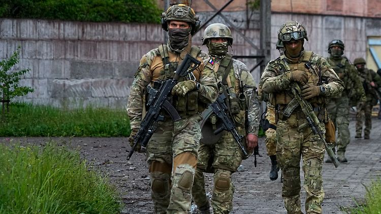 Russische Soldaten gehen durch einen zerstörten Bereich des Iljitsch Eisen- und Stahlwerks Mariupol.