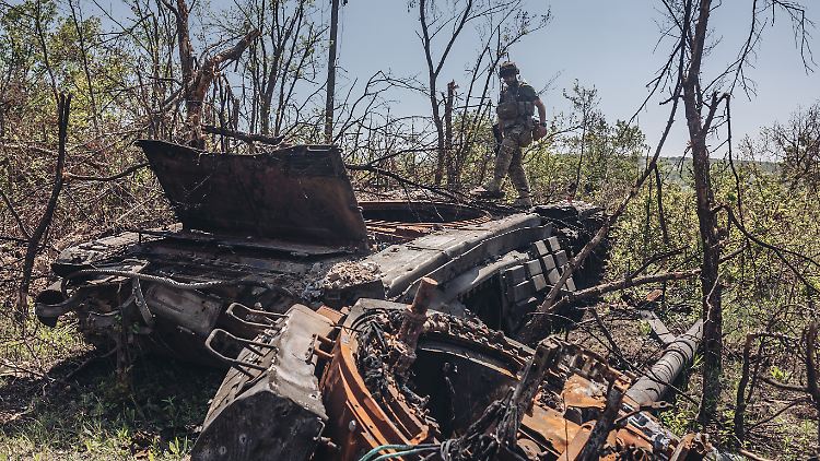 Ein ukrainischer Soldat an der Frontlinie in Luhansk besteigt einen zerstörten russischen Panzer.