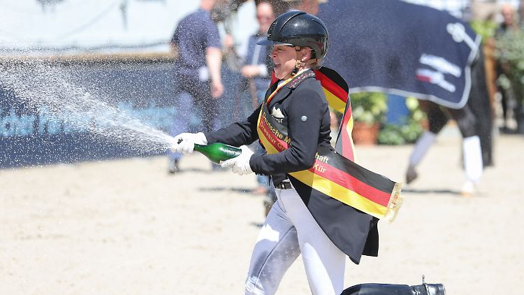 Isabell Werth feiert mit Champagner.