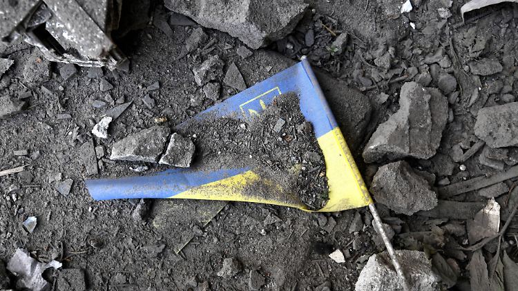 Eine ukrainische Fahne liegt nach einem Raketeneinschlag in den Trümmern. 