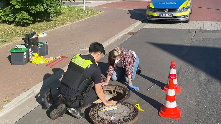 Polizisten untersuchen den Gully, in dem der seit acht Tagen vermisste Achtjähriger aus Oldenburg lebend gefunden wurde.