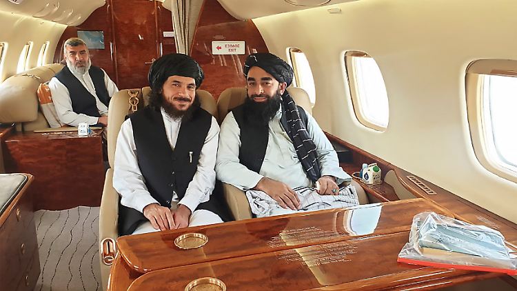 Von Taliban-Vertretern eingerahmt, fliegt der ehemalige Guantanamo-Insasse Haroon nach Afghanistan.