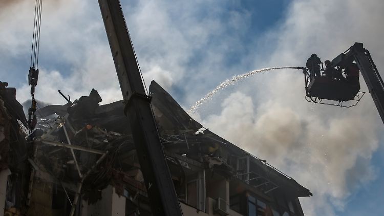 Die Feuerwehr löscht die Flammen in einem mehrstöckigen Wohnhaus in Kiew. Dort waren am Morgen Raketen eingeschlagen. 