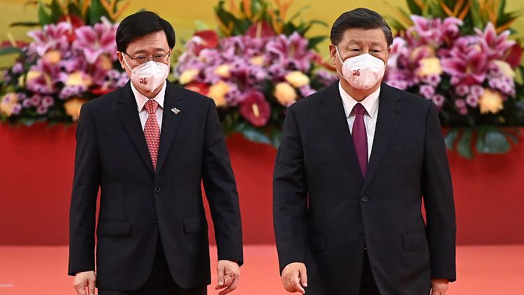 Hongkongs neuer Regierungschef John Lee (l) verlässt neben Xi Jinping (r), Chinas Präsident, nach einer Vereidigungszeremonie die Bühne.
