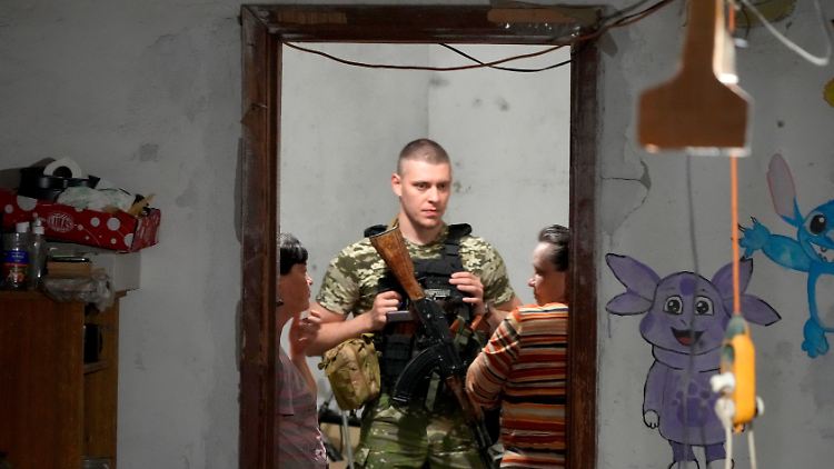 Ein ukrainischer Soldat spricht mit im Keller verschanzten Frauen in Lyssytschansk. Am Abend verkündet Kiew den Rückzug aus der Stadt.