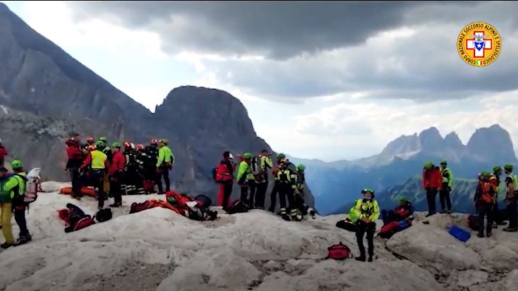 Das Foto zeigt Menschen nahe des Gletscherruchs in den Dolomiten.