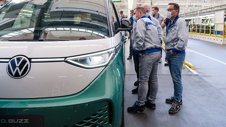 VW-Mitarbeiter vor einem ID Buzz: In den kommenden Monaten soll bei deutschen Herstellern mehr produziert werden.