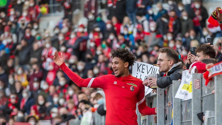 Kevin Schade jubelt mit den Freiburger Fans. 