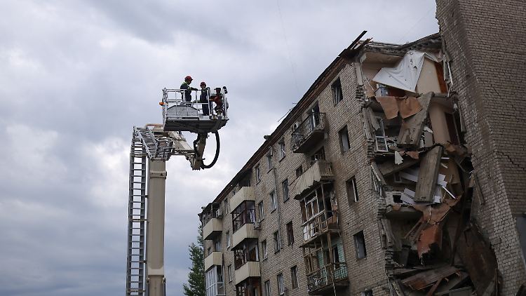 Einsatzkräfte der Feuerwehr suchen unter den Trümmern eines Wohnhauses nach Verschütteten. 