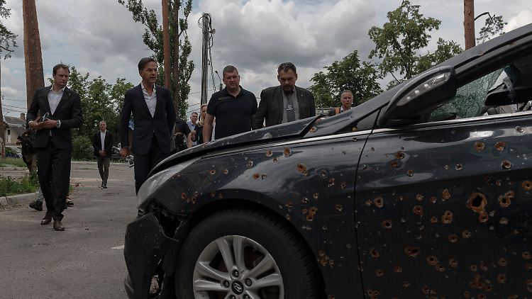 Während seines Besuchs in Irpin nimmt der niederländische Premier ein durch Granatenbeschuss beschädigtes Auto in den Blick.