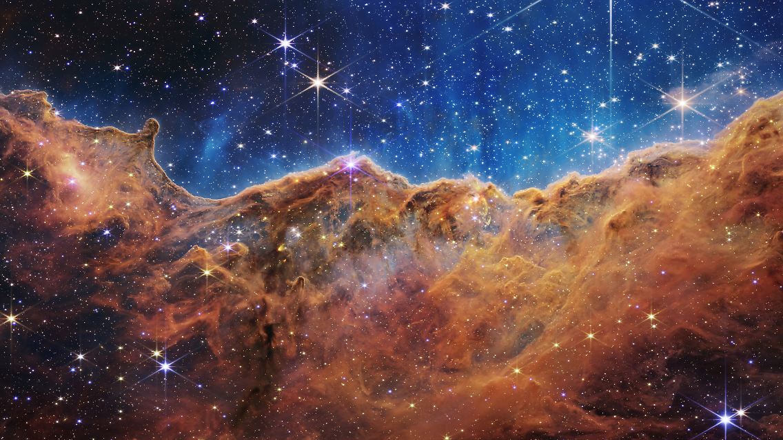 Diese Landschaft aus "Bergen" und "Tälern", gesprenkelt mit glitzernden Sternen, ist in Wirklichkeit der Rand eines nahen, jungen Sternentstehungsgebiets namens NGC 3324 im Carina-Nebel.