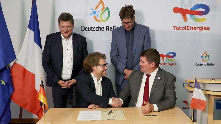 Ein Handschlag zwischen zwei Firmenvertretern für Lubmin, unter Beobachtung von Mecklenburg-Vorpommerns Wirtschaftsminister Meyer (l.) und Wirtschaftsstaatssekretär Kellner (2.v.r.).