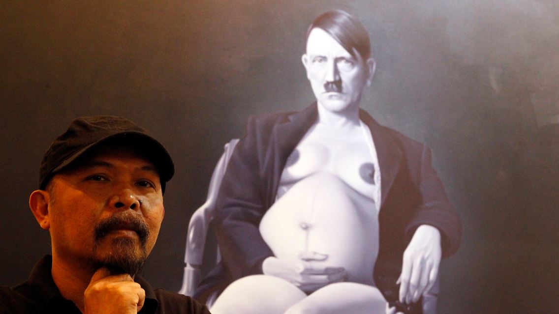 Maler Ronald Manullang vor einem seiner Werke.