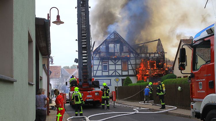 Die Feuerwehr kämpft gegen die Flammen, die auch ein Fachwerkgebäude erfasst haben.
