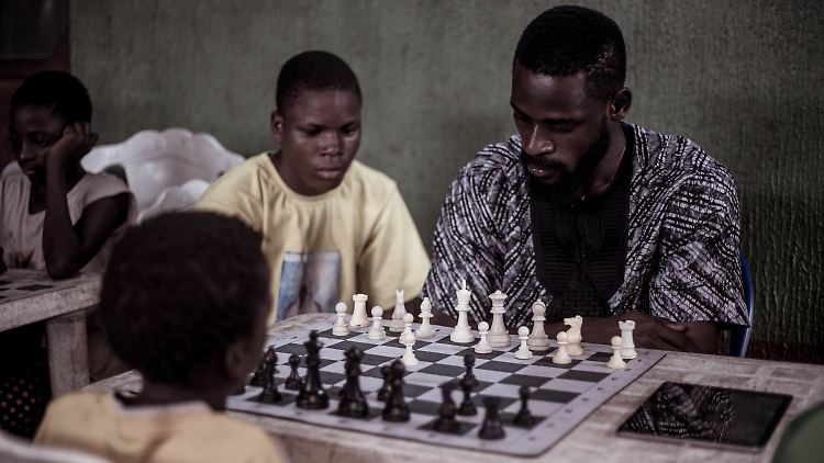 Babtunde Onakoya, der Gründer der Organisation "Chess in Slums", beim Schachspielen mit Kindern.