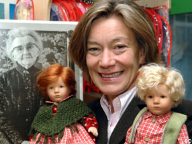 Die Geschäftsführerin der "Käthe-Kruse-Puppen", Andrea Kathrin Christenson, steht mit zwei Puppen in der Fabrik in Donauwörth.