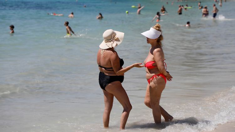 Zwei Frauen unterhalten sich am Strand von Palmanova auf Mallorca (Archivbild).