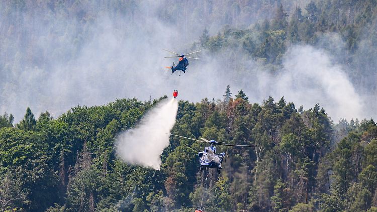 Hubschrauber der Bundespolizei fliegen mit einem Löschwasser-Außenlastbehälter, um einen Waldbrand im Nationalpark Sächsische Schweiz zu löschen.