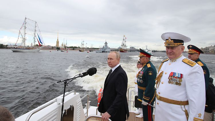 Putin (l.) nahm zusammen mit Verteidigungsminister Schoigu und Admiral Nikolai Jewmenow die Marine-Parade in St. Petersburg ab.