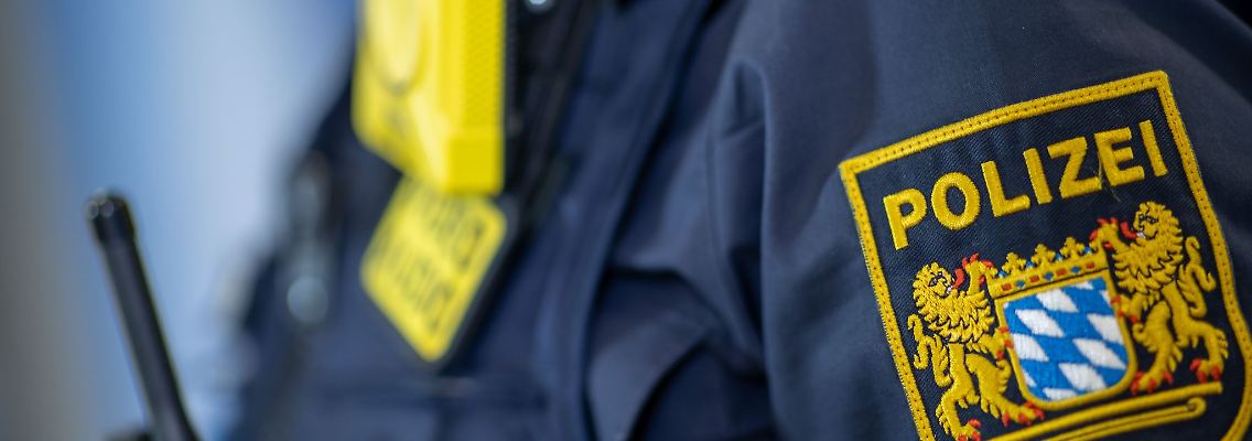 Eine Polizistin trägt ein Abzeichen der bayerischen Polizei.