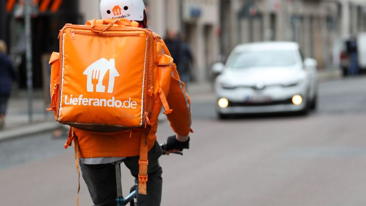 Ein Fahradbote vom Lieferdienst Lieferando.de fährt durch die Innenstadt von Leipzig.