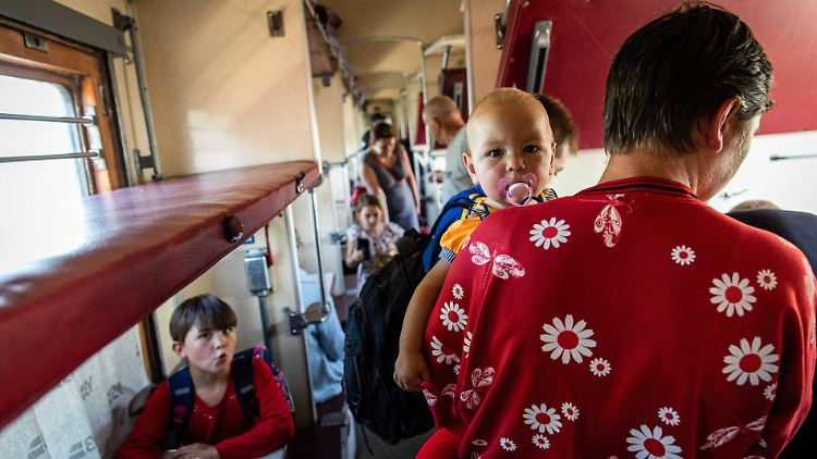 Eine Mutter besteigt mit ihrem Baby einen Evakuierungszug im Donbass.