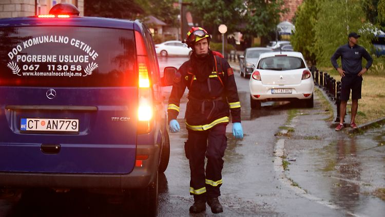 Ein Feuerwehrmann geht an einem Leichenwagen am Ort des Amoklaufs vorbei.