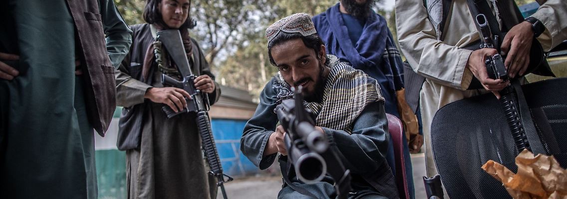 Ein junger Taliban-Kämpfer zielt zum Spaß mit seinem Gewehr in Richtung Fotograf, während er vor einer Polizeistation in Kabul Wache hält.