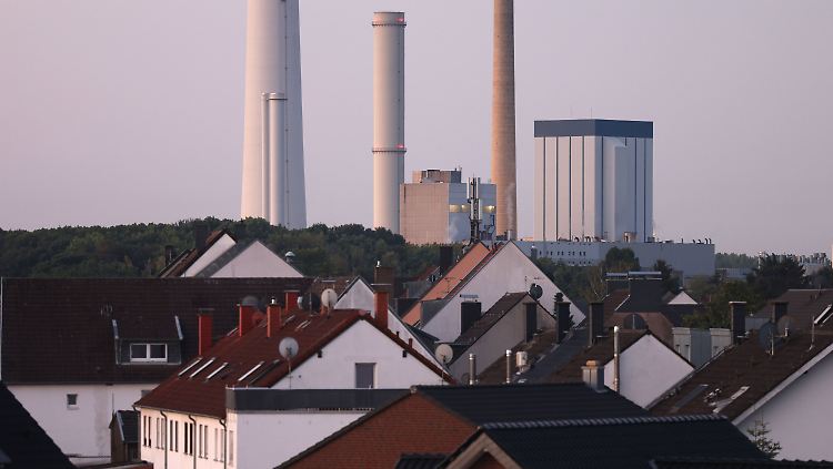 Das Heizkraftwerk Köln Merkenich des Energieversorgers RheinEnergie ist hinter Wohnhäusern zu sehen.