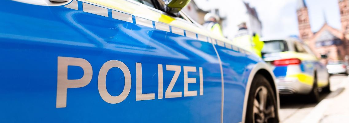Zwei Streifenwagen der Polizei stehen am Straßenrand.