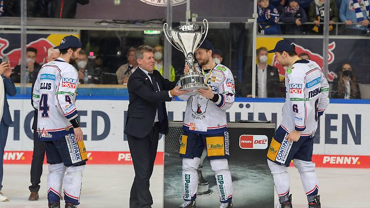 DEL-Boss Tripcke überreicht den Eisbären den Meisterpokal.