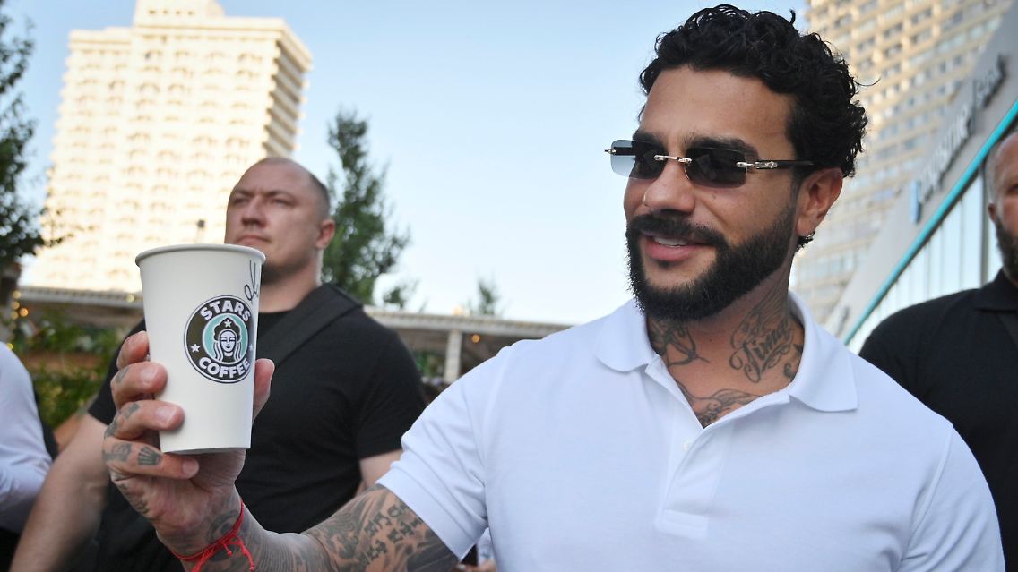Timati mit einem Becher von "Star Coffee".