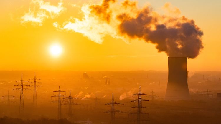 Die Sonne geht neben einem Kühlturm des STEAG Kraftwerk auf.
