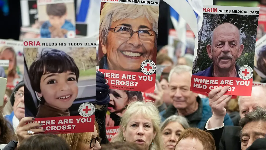 Eine-Person-haelt-ein-Poster-von-Vivian-Silver-oben-M-waehrend-medizinisches-Personal-und-Mitarbeiter-des-Gesundheitswesens-an-einer-Demonstration-vor-dem-Internationalen-Komitee-des-Roten-Kreuzes-IKRK-teilnehmen-und-ein-sofortiges-Eingreifen-im-Fall-der-am-7-Oktober-aus-Israel-entfuehrten-Geiseln-fordern